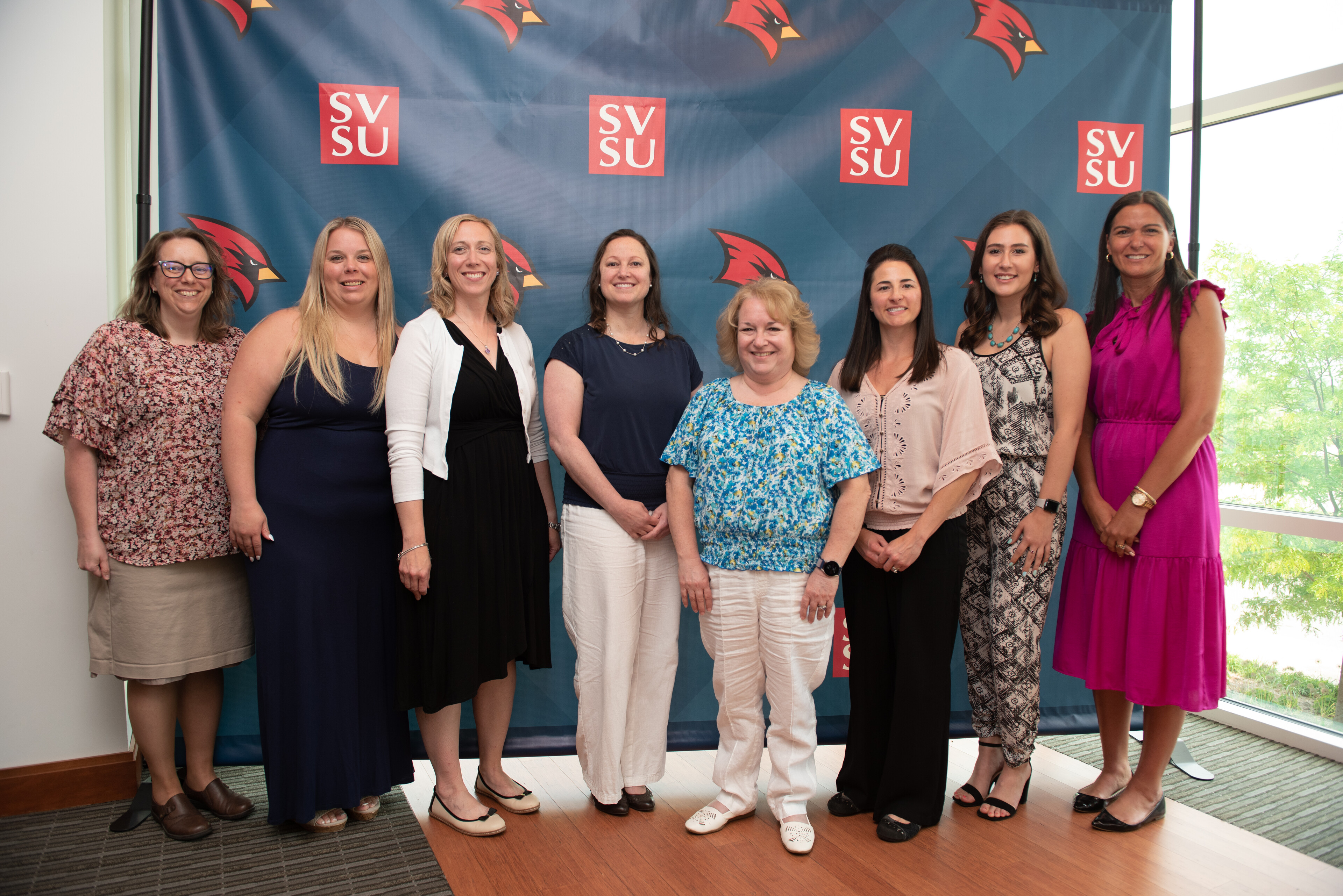 Group of women standing in front of SVSU backdrop